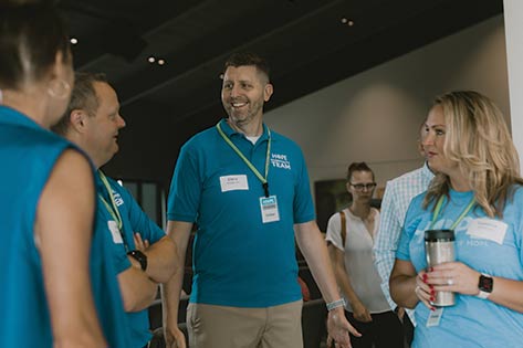 Group of volunteers smiling and chatting in a circle