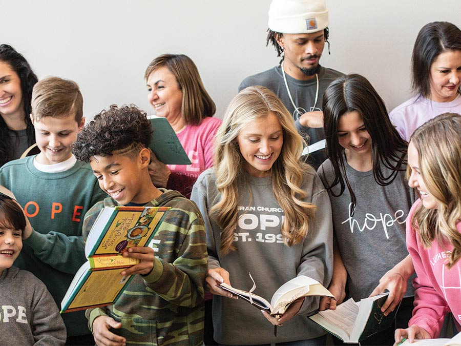 Group of people smiling and holding open bibles
