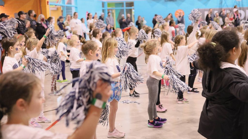 Gym full of kiddos holding pom poms during the Dance and Cheer Clinic