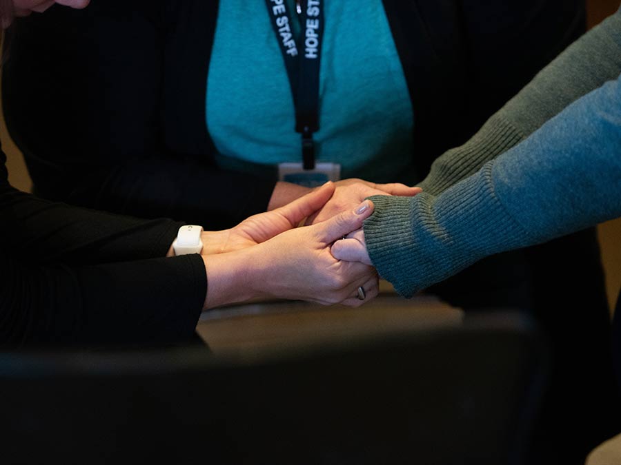 Someone receiving support and prayer by a staff member and prayer partner