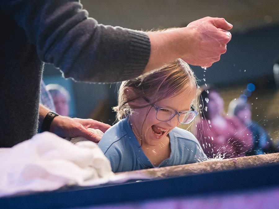 Young girl joyfully being baptized