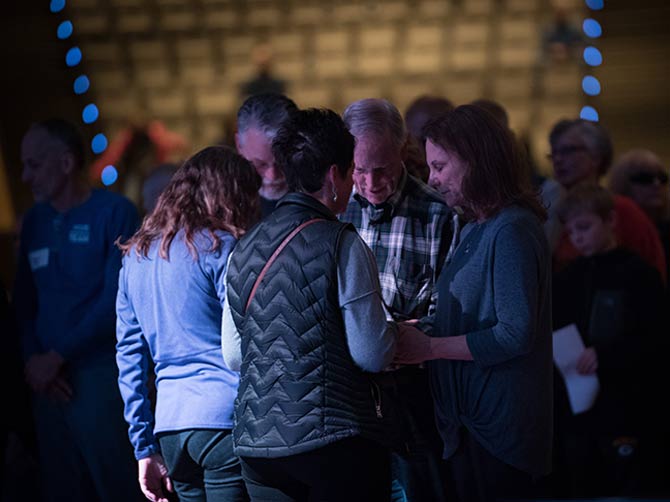 Family praying together with a prayer partner