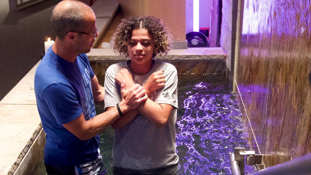 Young person being baptized in the baptismal font