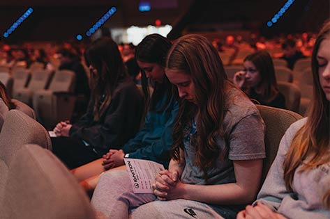 Ignition high school students praying in the worship center