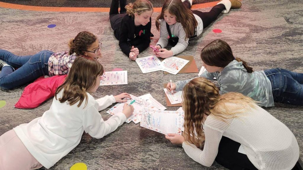 Girls coloring in a circle.