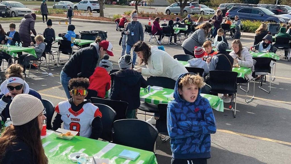 Moms and sons enjoy snacks at tables