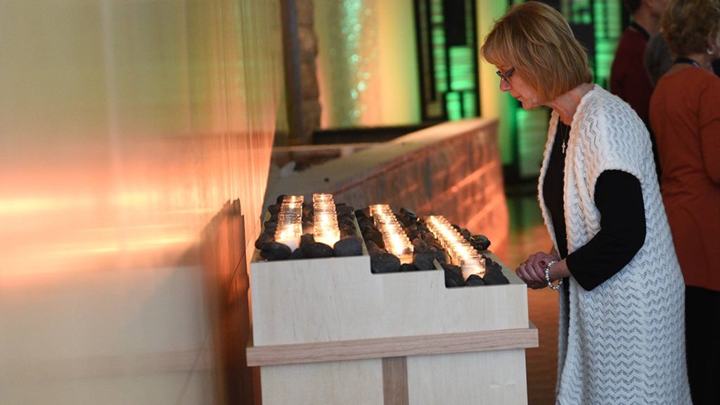 Church member lighting prayer candle in the Worship Center
