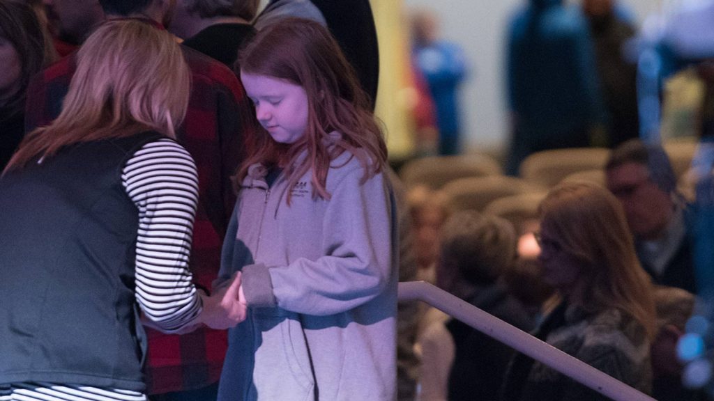 Elementary girl receiving prayer from Hope prayer partner after worship service