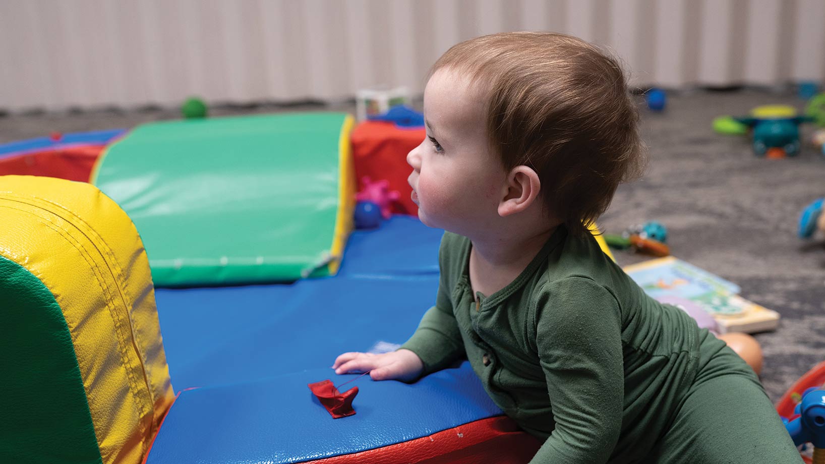 Small toddler on colorful playmat