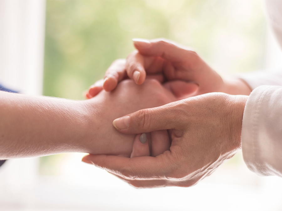 Hands of an old woman touch the hands of a young girl, closeup. Psychological assistance, the doctor is a therapist, a psychologist takes the patient's hand. Give hope