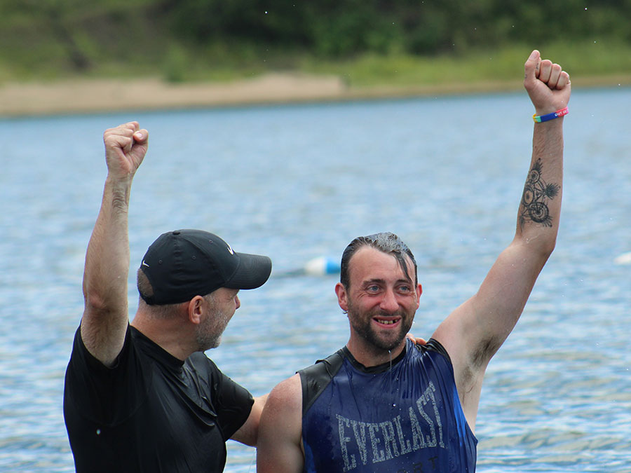 two men raising fists from a man being baptized