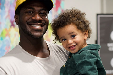 Man holding child and both smiling