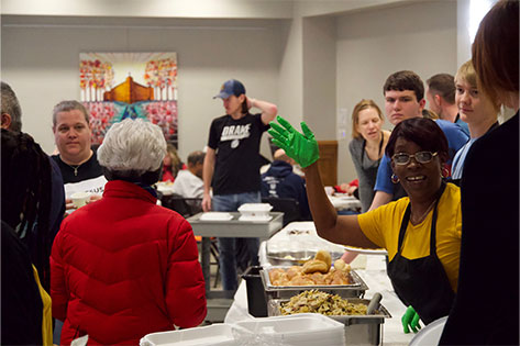 Woman waving while serving food