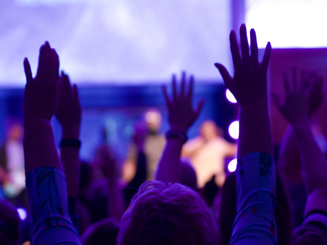 People with hands up worshipping