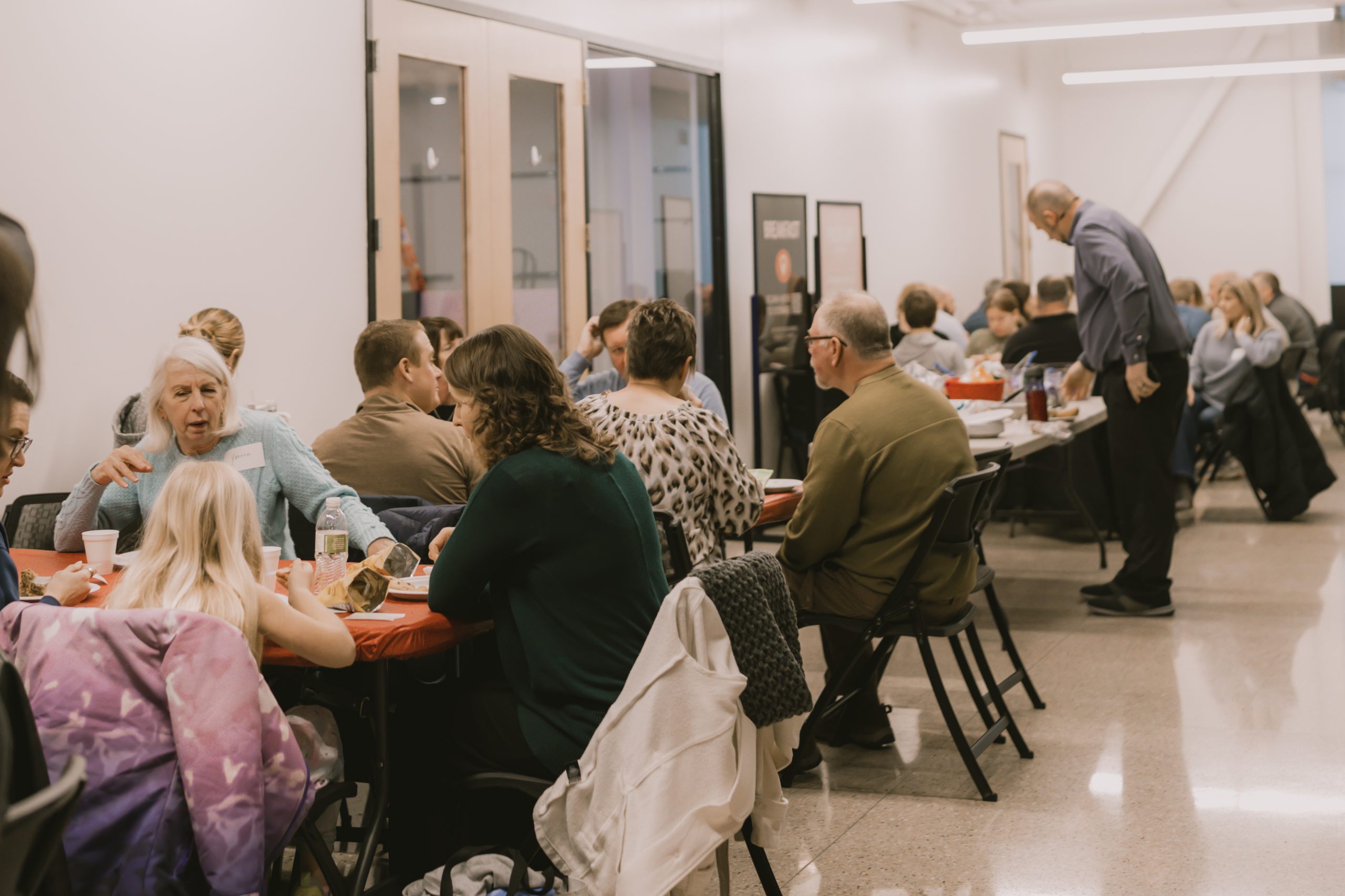 Members of church eating lunch after a New Member Class with Pastor answering questions