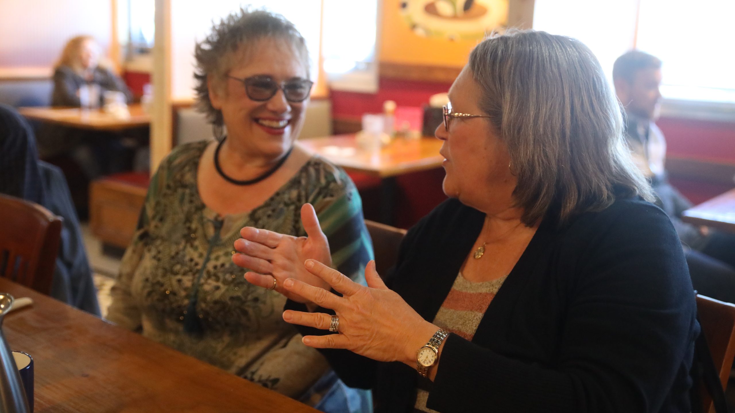 Women talking during 50+ event at cafe
