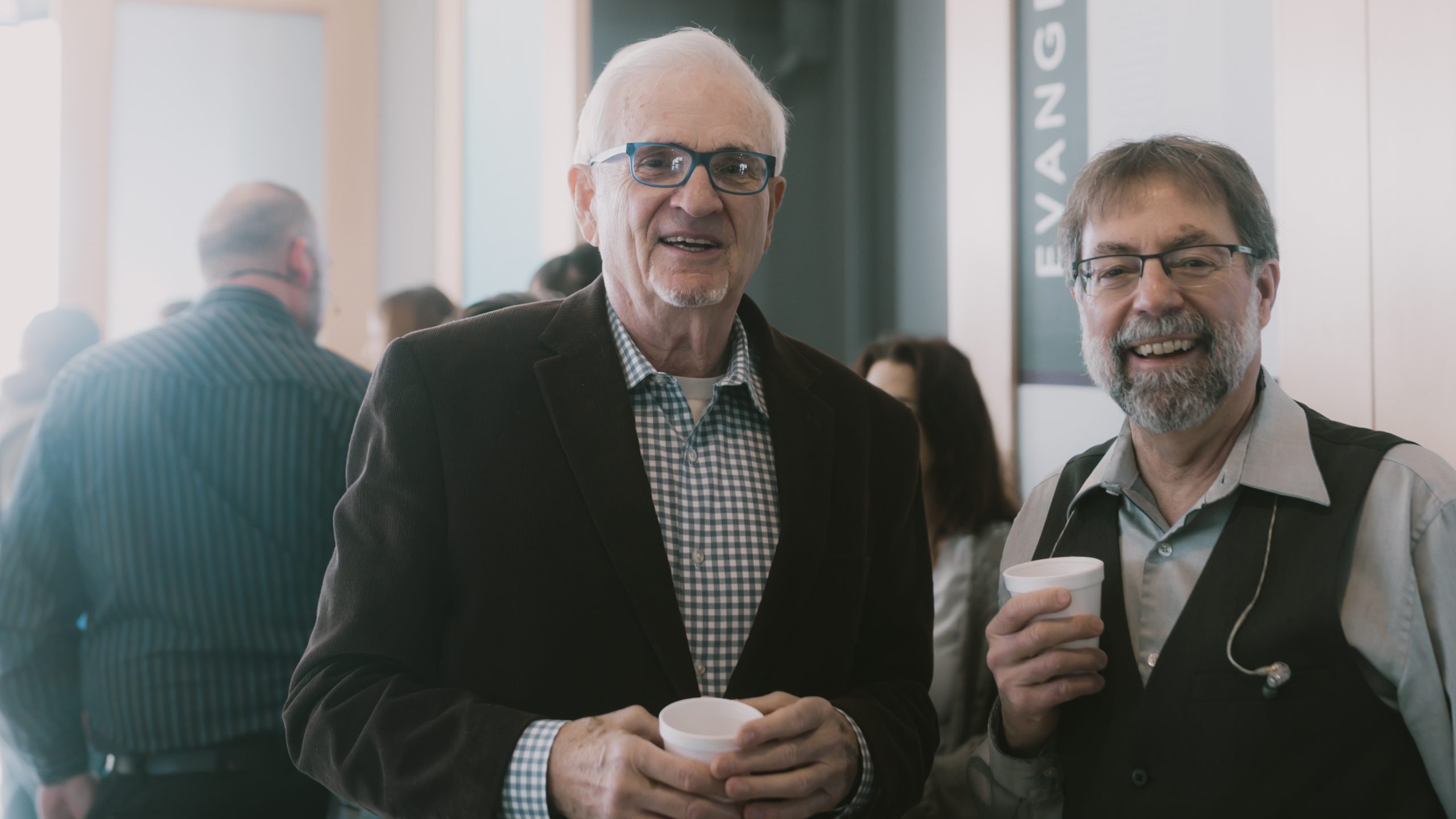 Two men holding coffee after worship