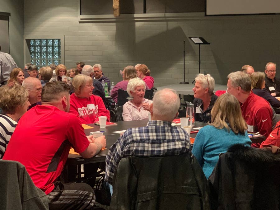 A group of people at table at Alpha listening to one another