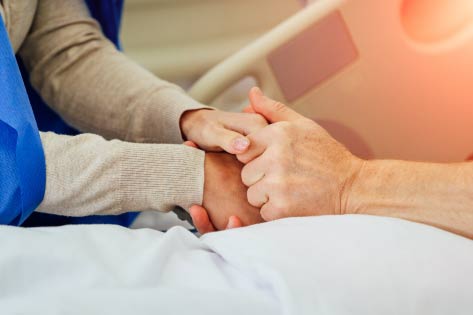 Holding hands in hospital bed