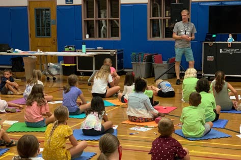 Kids sitting on foam mats in the gym during HopeKids